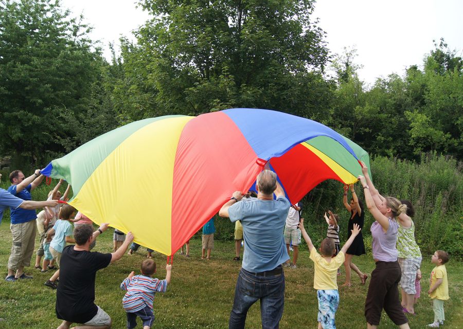 Familien, die gemeinsam ein buntes Tuch spannen