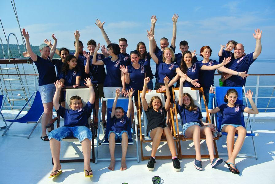 Gruppenfoto von Kindern, die freudig die Hände in die Luft werfen
