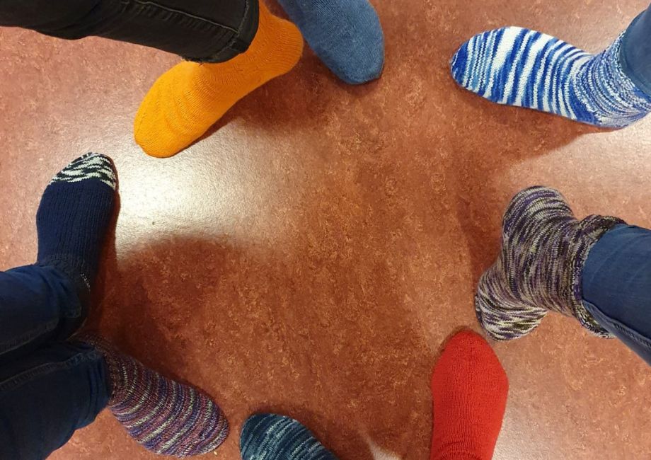 Menschen die im Kreis mit Socken stehen