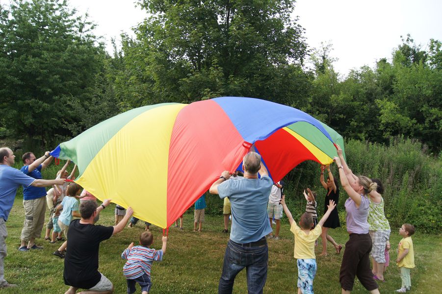 Familien spannen gemeinsam ein buntes Segeltuch